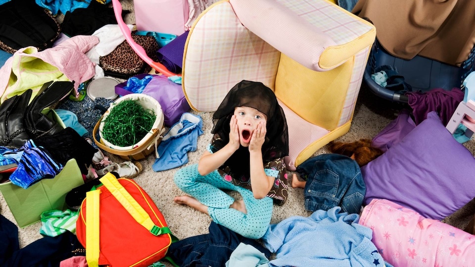 Child seaching through a messy room