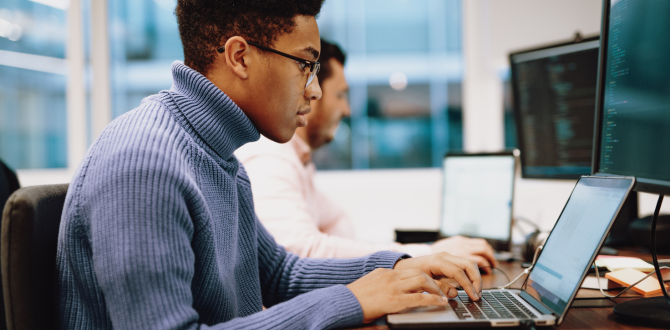 Egy fiatal fekete fiú, szemüveges, egy laptop képernyőjén kódolást néz.